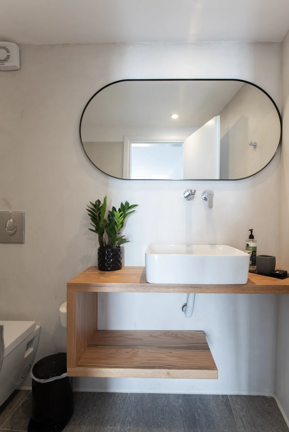 Bathroom with oval mirror and wooden vanity